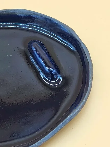 Okrągła ceramiczna podstawka w głębokim kobaltowym odcieniu, wykonana ręcznie w Krakowie, prezentująca bezpieczne użycie z Palo Santo.