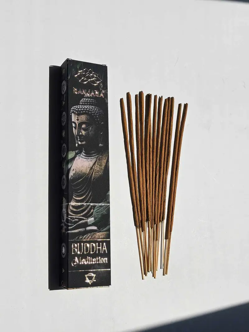 Oryginalne grafitowe opakowanie kadzidełek BANJARA Buddha Meditation obok naturalnych patyczków masala i drewnianej podstawki.