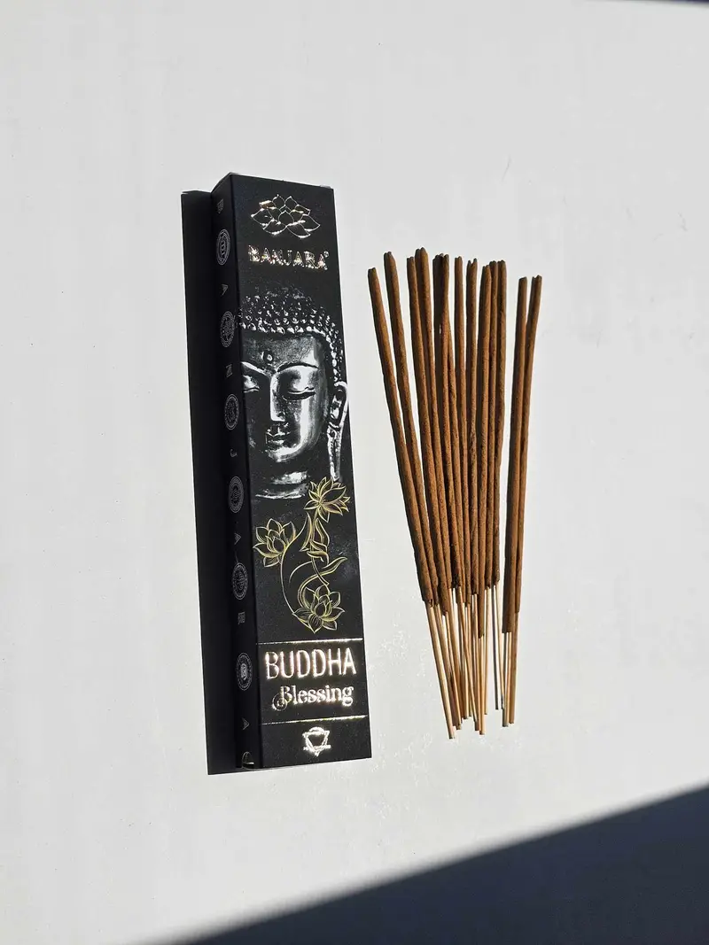 Oryginalne brązowe opakowanie kadzidełek BANJARA Buddha Blessing ze złotym wizerunkiem Buddy obok naturalnych patyczków masala.