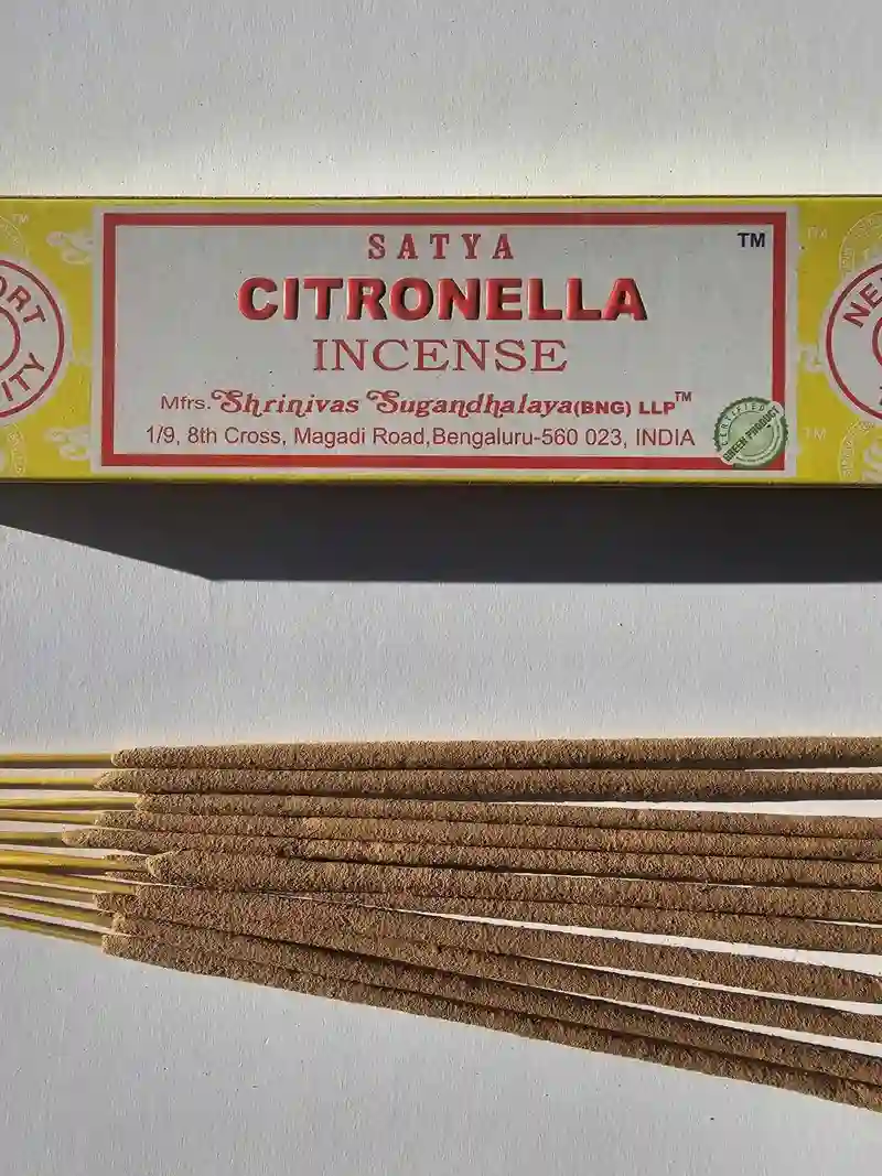 Oryginalne żółto kremowe opakowanie indyjskich kadzidełek SATYA Citronella obok naturalnych patyczków masala.
