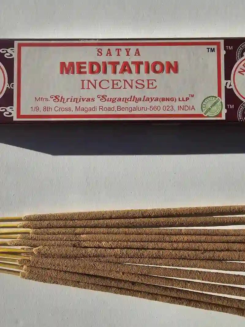 Oryginalne brązowo kremowe opakowanie indyjskich kadzidełek SATYA Meditation obok naturalnych patyczków masala.