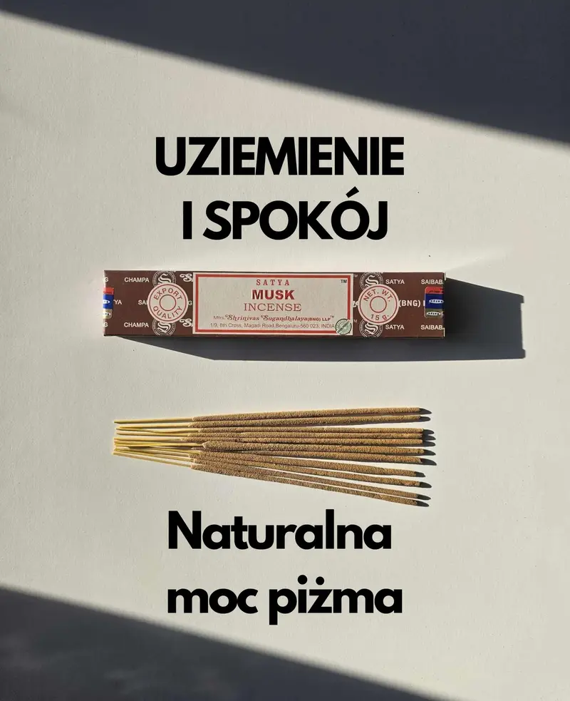 Oryginalne ciemnobrązowo kremowe opakowanie indyjskich kadzidełek SATYA Musk obok naturalnych patyczków masala.
