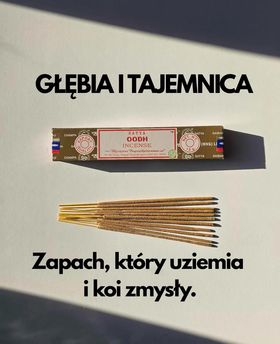 Ciemnobrązowe pudełko kadzideł Satya Oodh 15g leżące nad stosem jasnobrązowych patyczków na białym tle z wyraźnym cieniem rzucanym w prawą stronę.