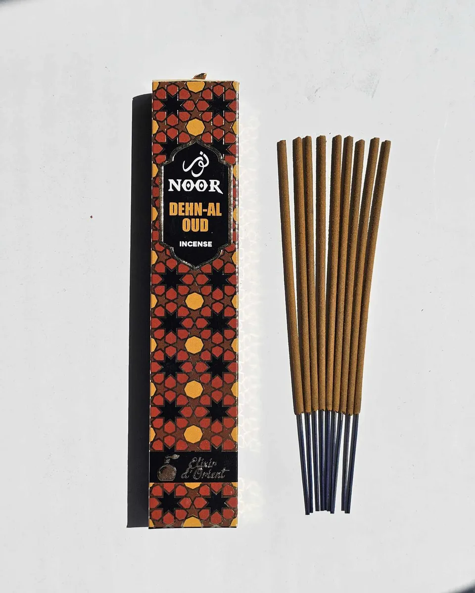 Luksusowe, ciemne opakowanie kadzideł Noor Dehn-Al Oud ze złotymi zdobieniami, prezentujące rozwiązanie dla osób szukających prestiżu i głębokiego, szlachetnego aromatu.