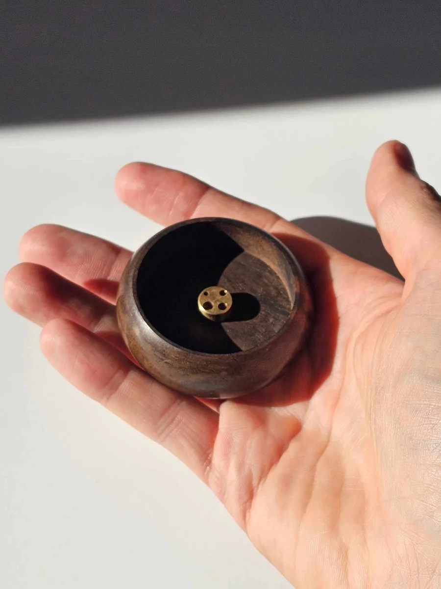 Mała, drewniana podstawka w dłoni, pokazująca jej kompaktowy rozmiar i przeznaczenie wyłącznie do kadzideł stożkowych.