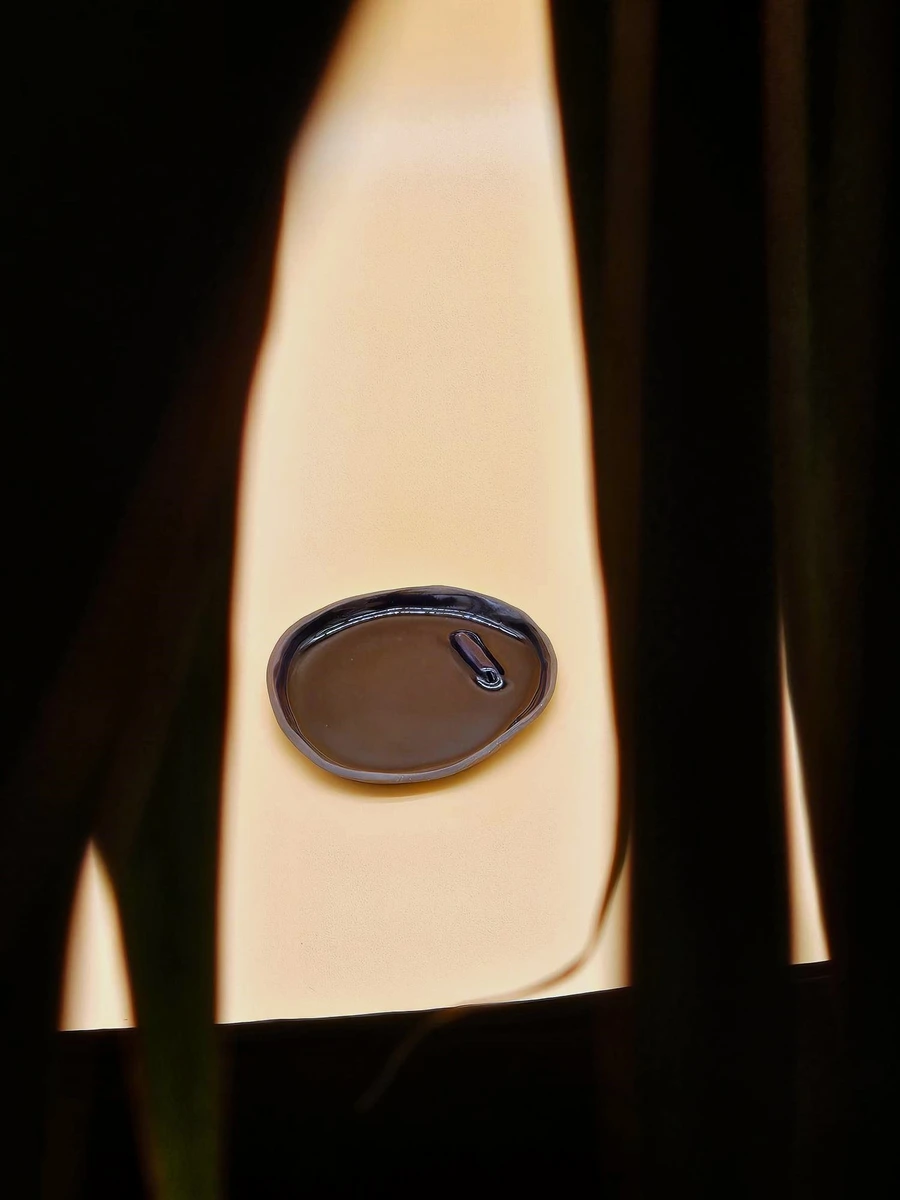 Okrągła ceramiczna podstawka w głębokim kobaltowym odcieniu, wykonana ręcznie w Krakowie, prezentująca bezpieczne użycie z Palo Santo.