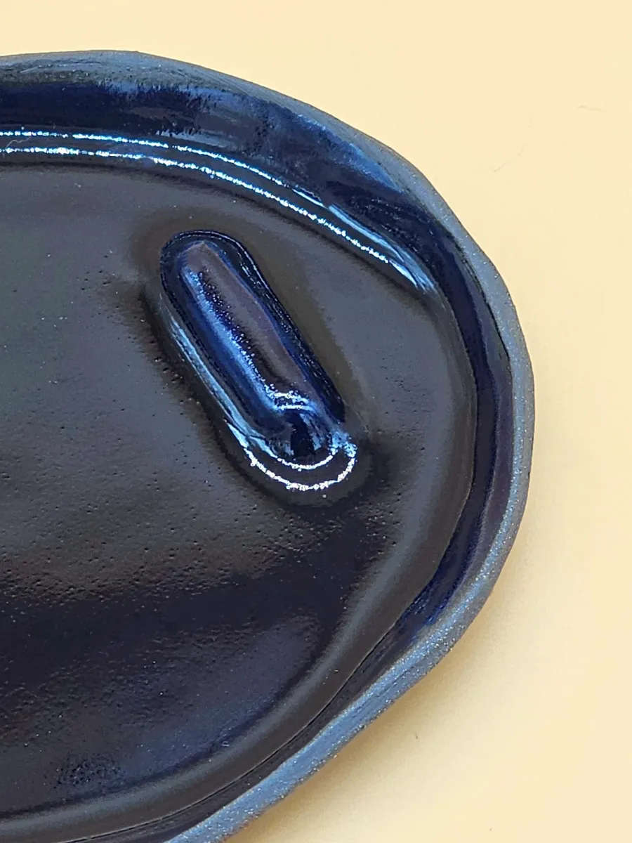 Okrągła ceramiczna podstawka w głębokim kobaltowym odcieniu, wykonana ręcznie w Krakowie, prezentująca bezpieczne użycie z Palo Santo.